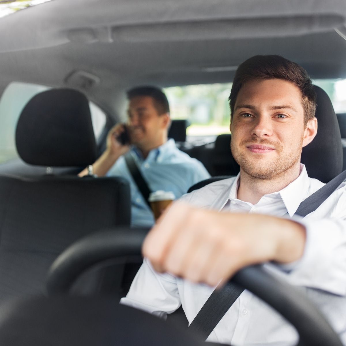 Happy driver with phone in car